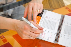 hands of woman by writing in a calendar